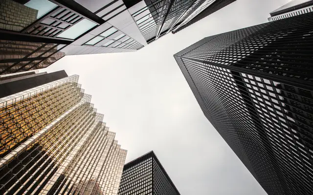 Looking up at gold and dark glass office towers downtown