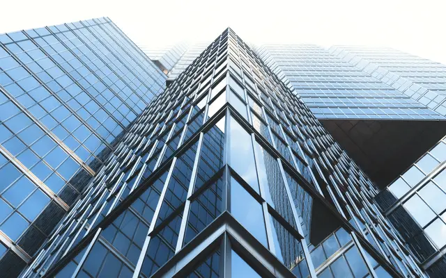 Blue glass office tower seen from street level