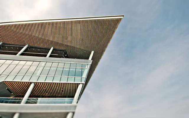 Modern building with a wide timber roof overhang and glass floors
