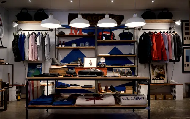 Interior of a small clothing boutique with shelves and hanging racks