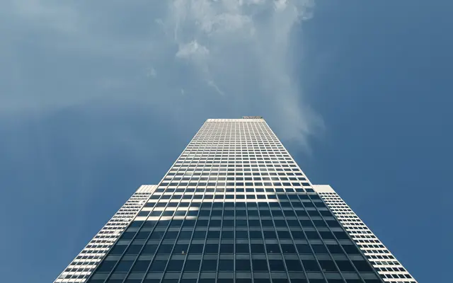 Office skyscraper seen from below under a blue sky