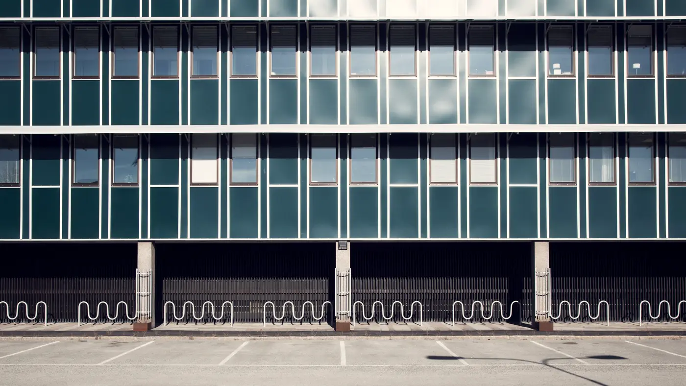 Glass office building facade above an empty parking lot