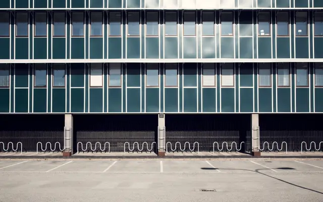 Glass office building facade above an empty parking lot