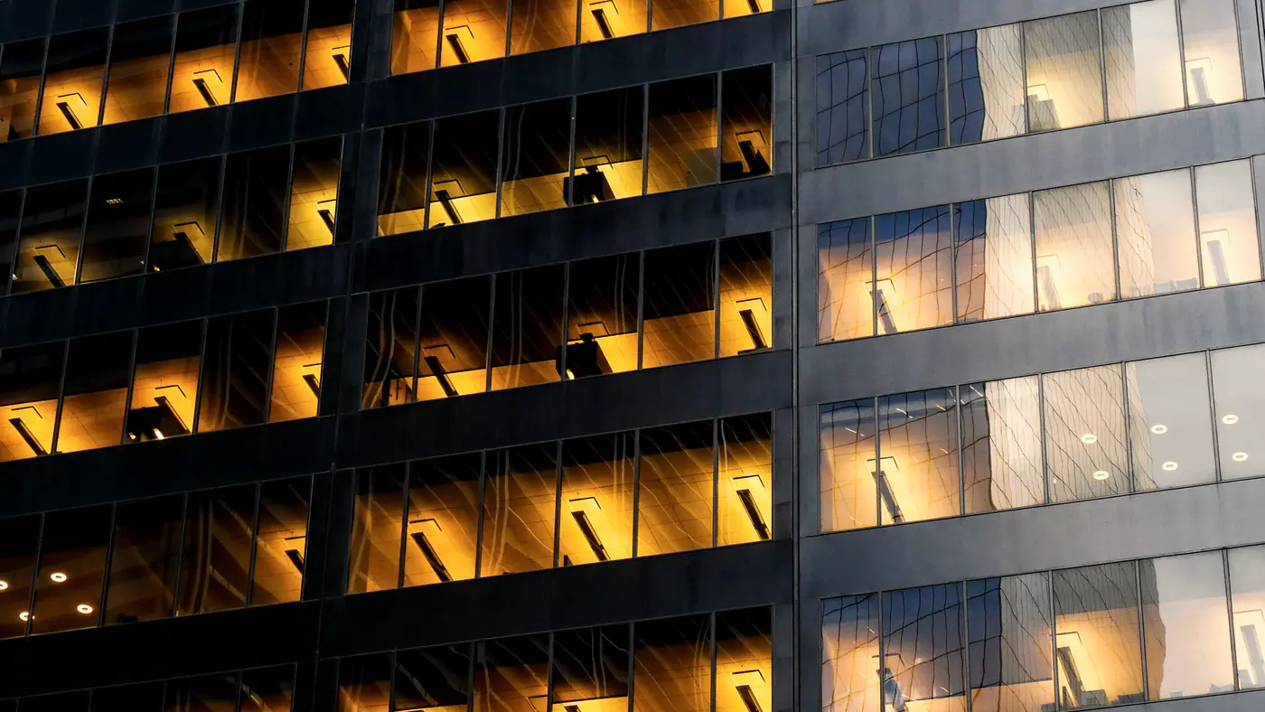 Office building facade with warmly lit windows at dusk