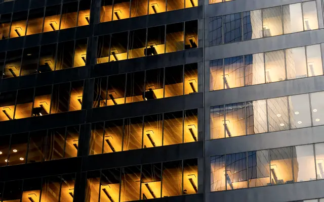 Office building facade with warmly lit windows at dusk