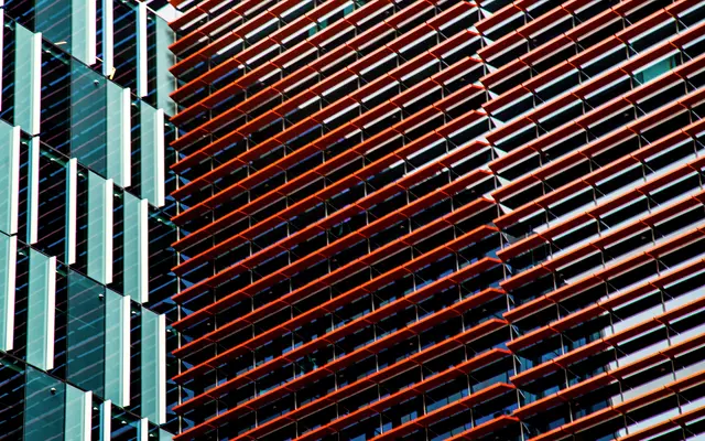 Modern facade of teal and rust colored vertical fins