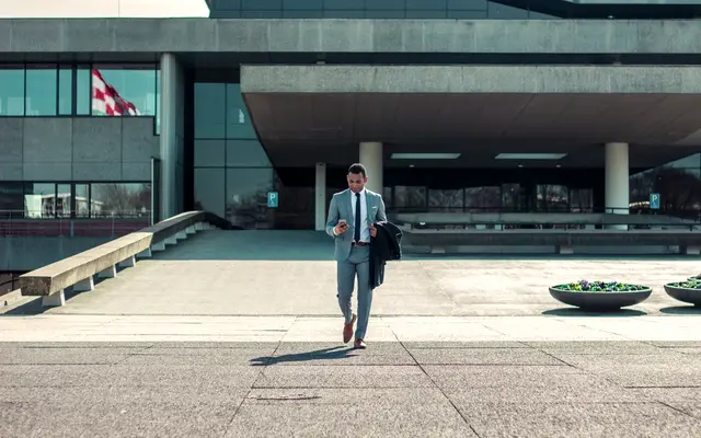 Businessman in a suit walking out of a modern building