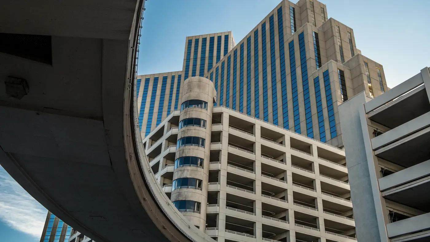 Office tower seen from beneath a curved concrete overpass