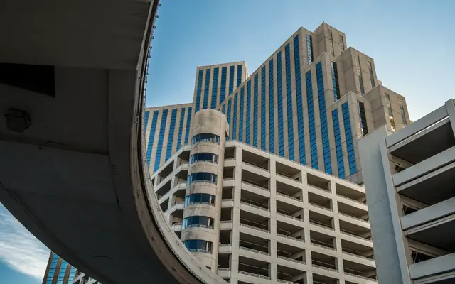 Office tower seen from beneath a curved concrete overpass