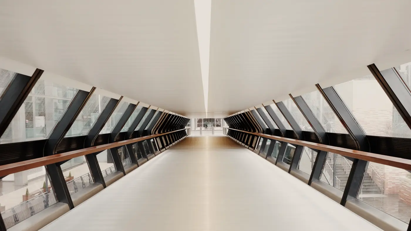 Bright enclosed glass walkway stretching into the distance