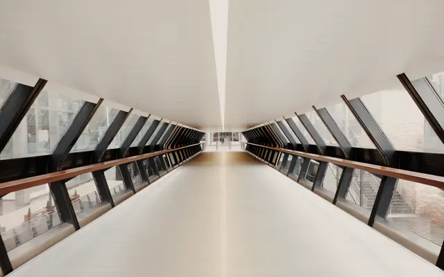 Bright enclosed glass walkway stretching into the distance