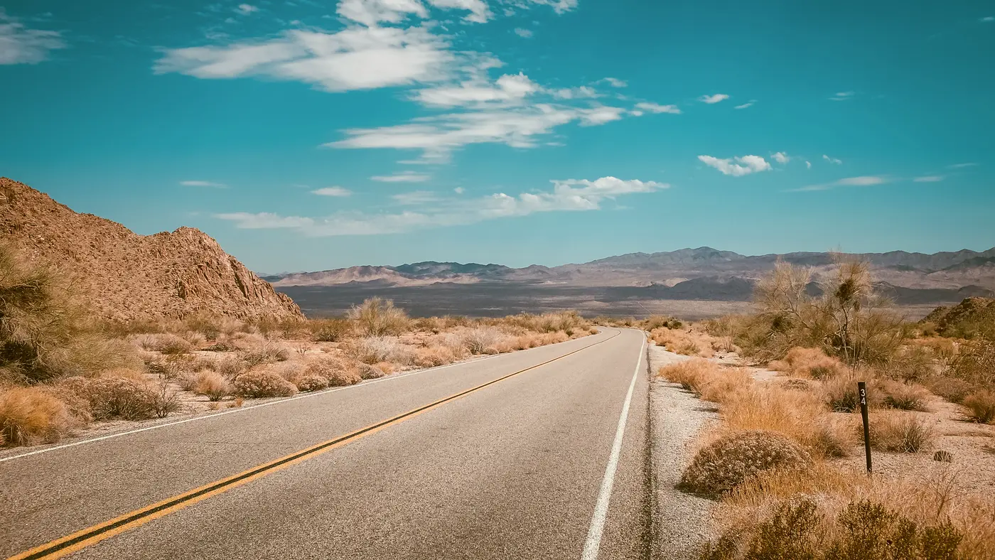 Empty desert highway under a bright blue sky
