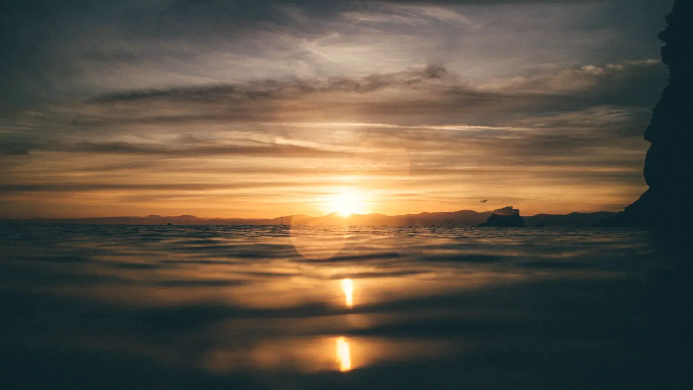 Calm sea at sunset with the sun low on the horizon