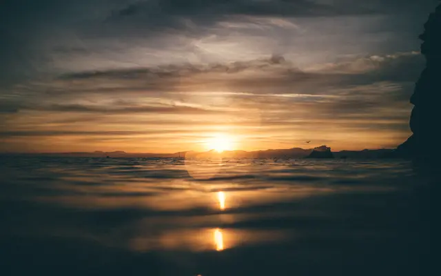 Calm sea at sunset with the sun low on the horizon
