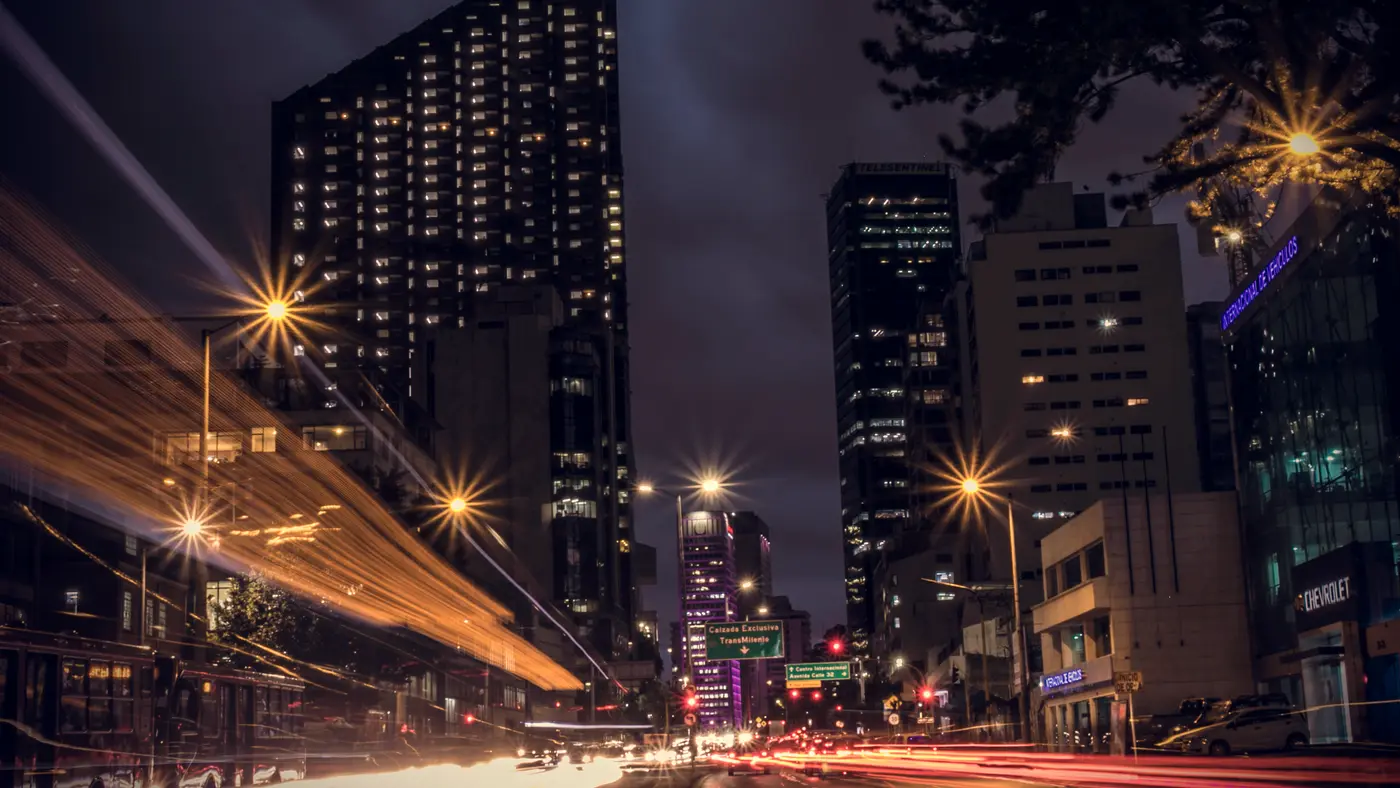 Downtown high-rises at night with streetlights and traffic light trails