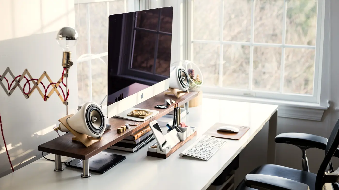 Home office desk with monitor beside tall sash windows