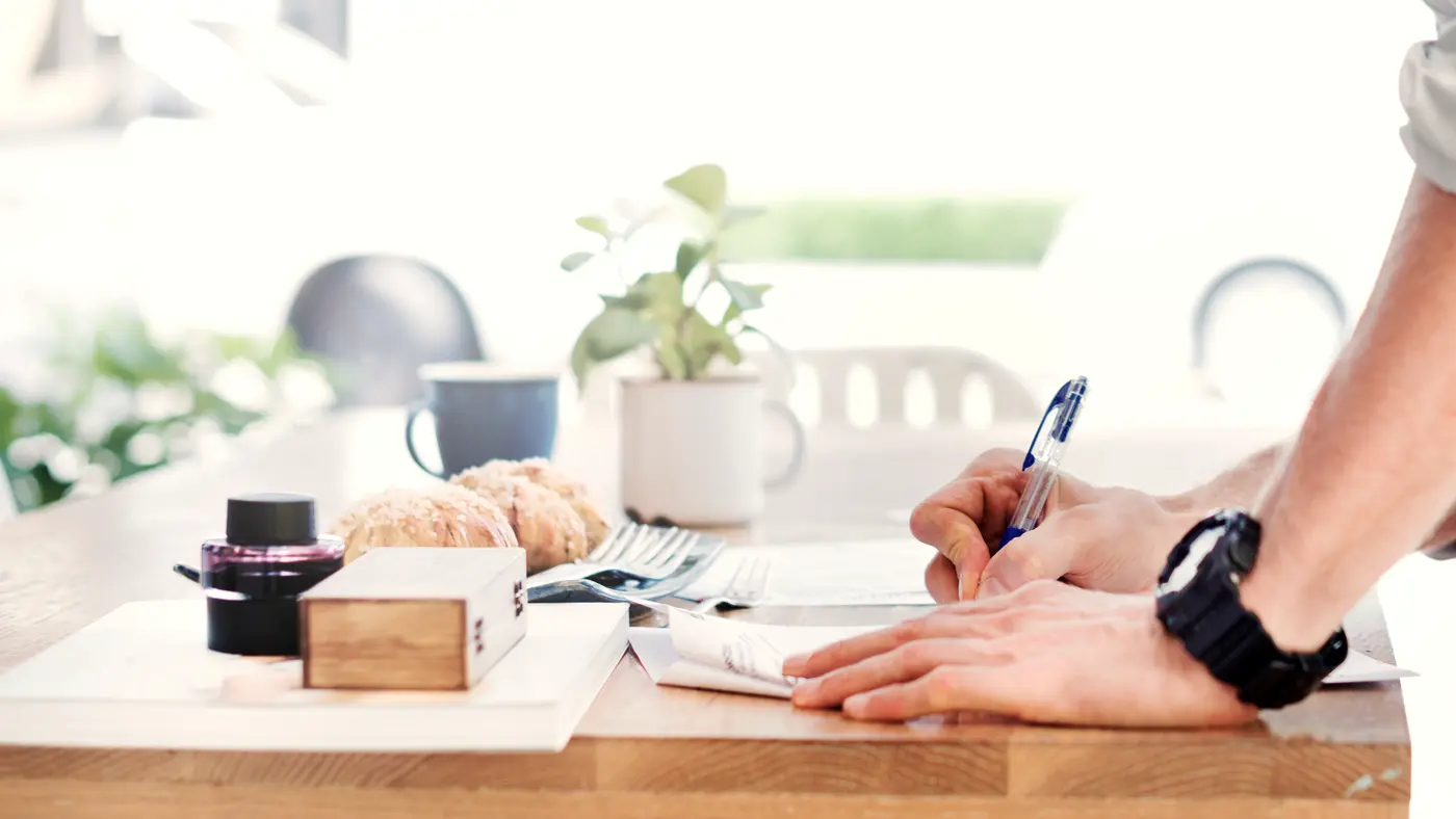 Hand writing on paper at a bright tidy desk