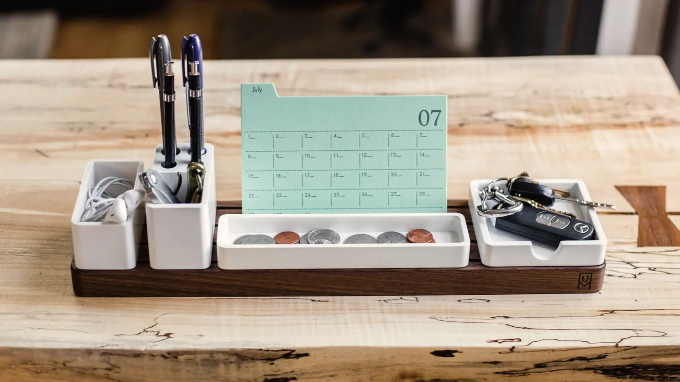 Wooden desk organiser holding pens, keys and a small calendar