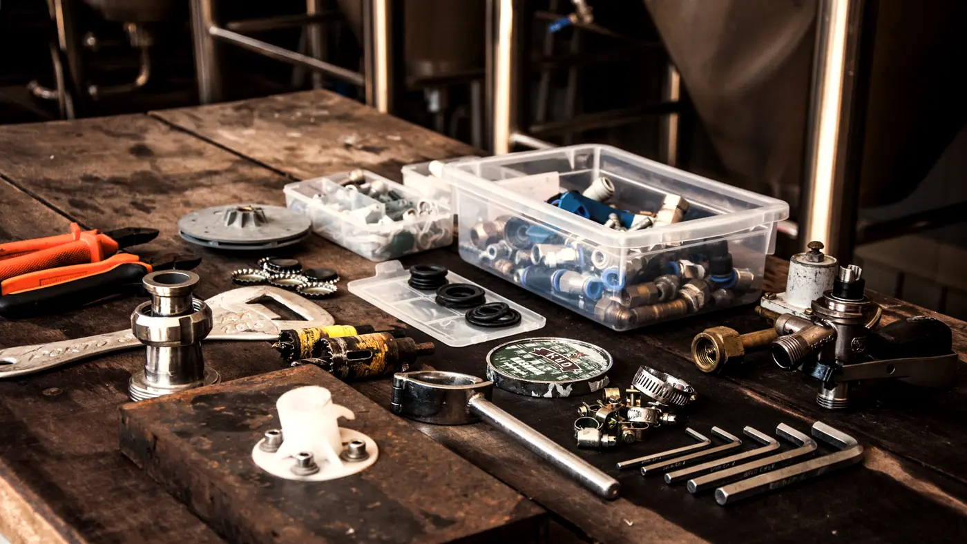 Hand tools and hardware laid out on a wooden workbench