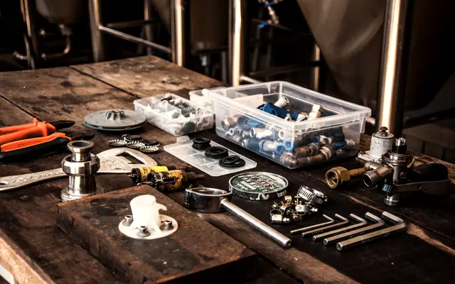 Hand tools and hardware laid out on a wooden workbench