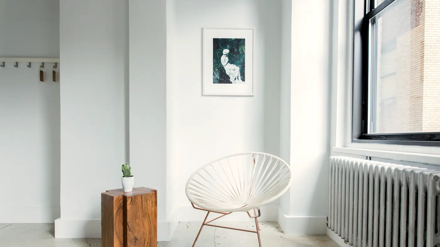 Bright empty white room with a single chair by the window