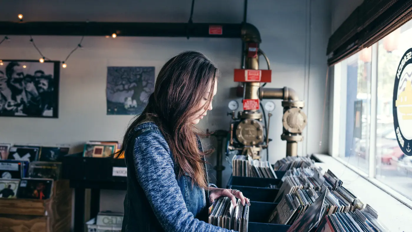 Woman browsing records in a small independent record shop