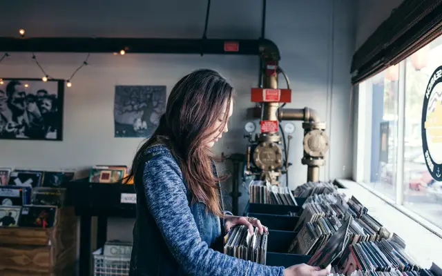 Woman browsing records in a small independent record shop