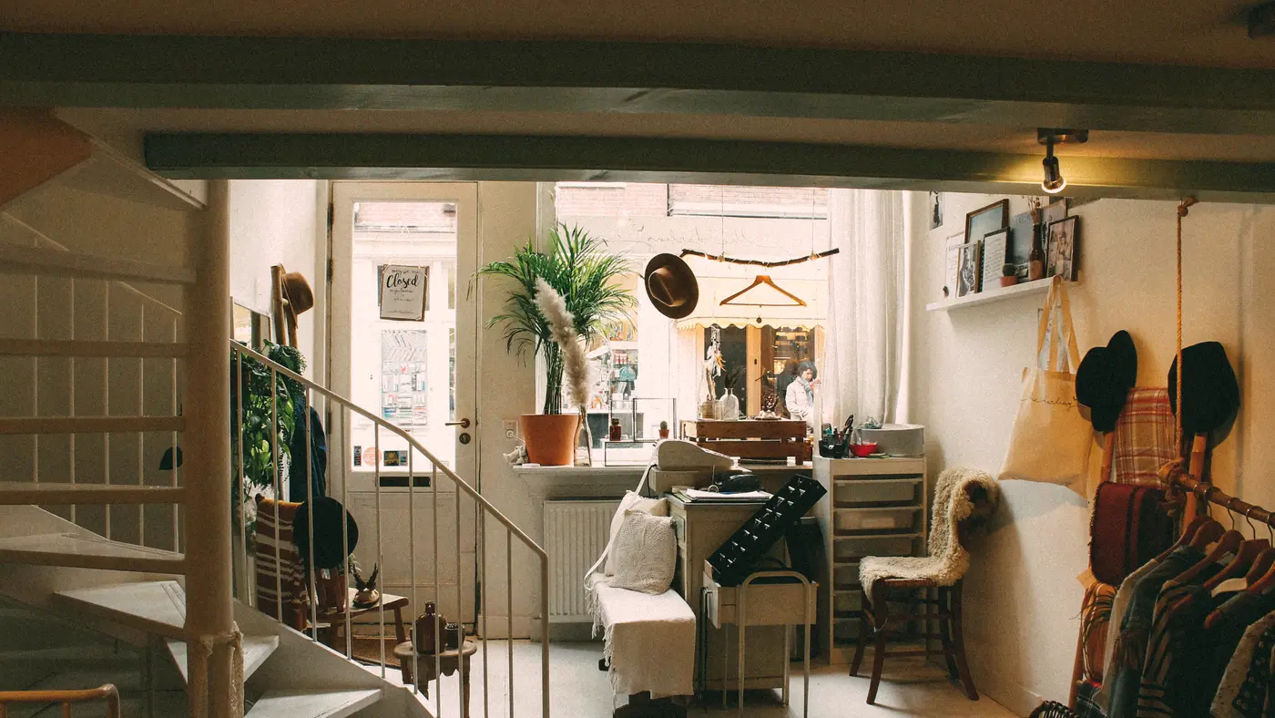Interior of a small boutique shop with clothing and plants