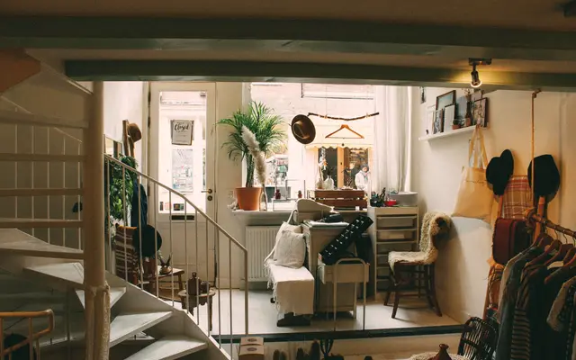 Interior of a small boutique shop with clothing and plants