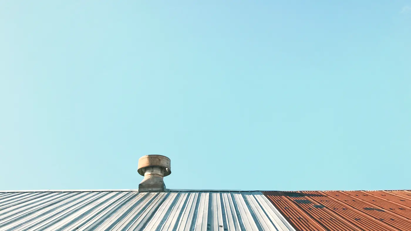 Metal roof with a ventilation turbine under a clear sky