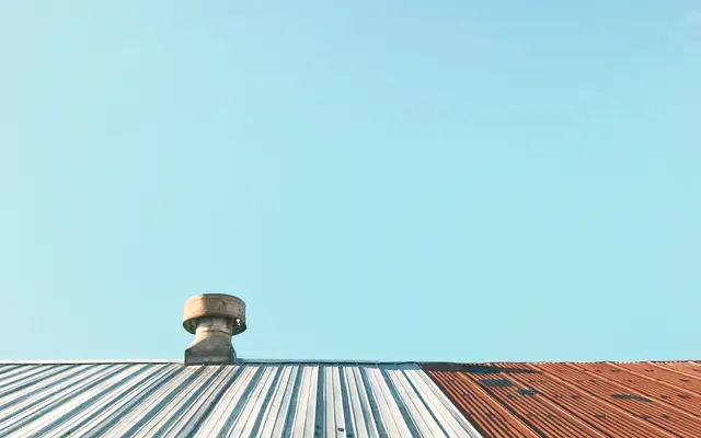 Metal roof with a ventilation turbine under a clear sky