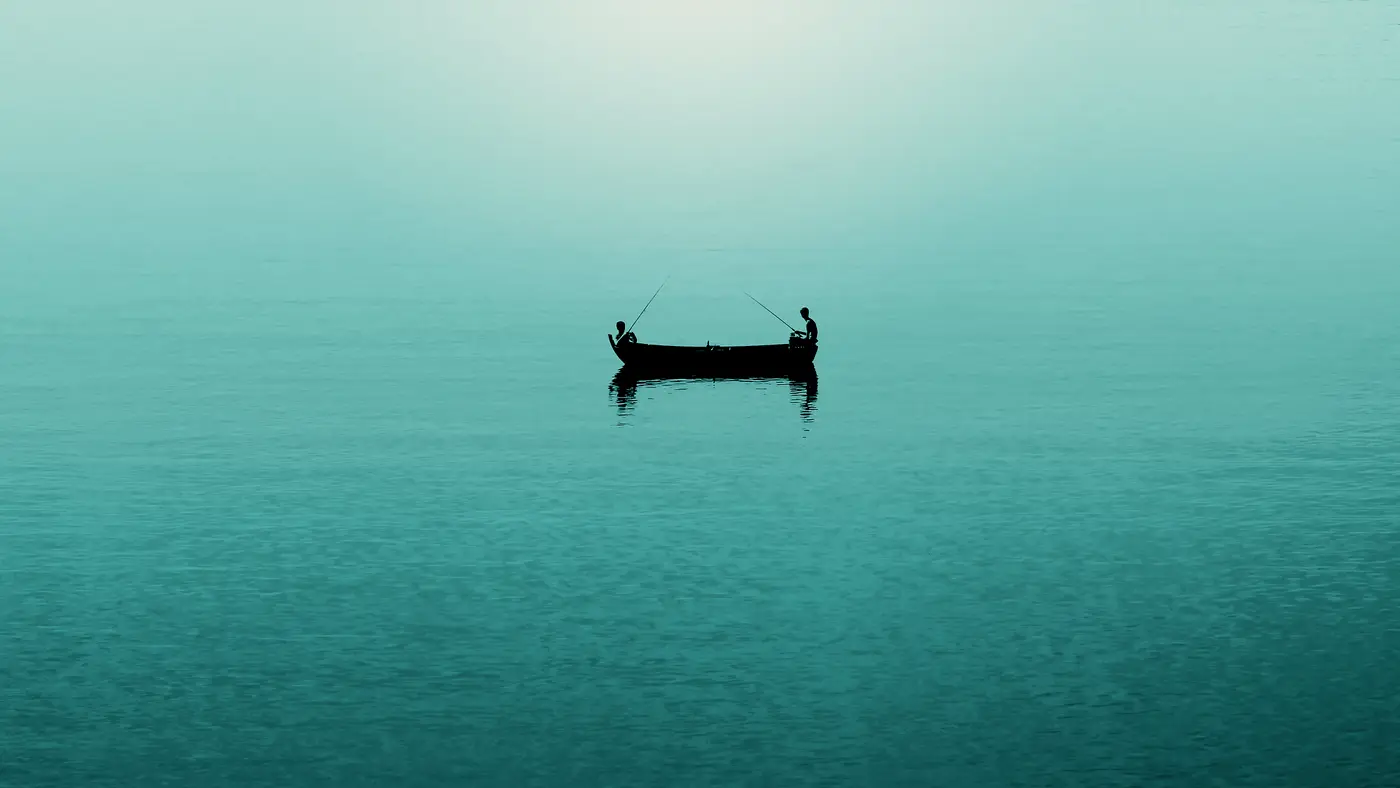 Two anglers in a small boat on calm teal water