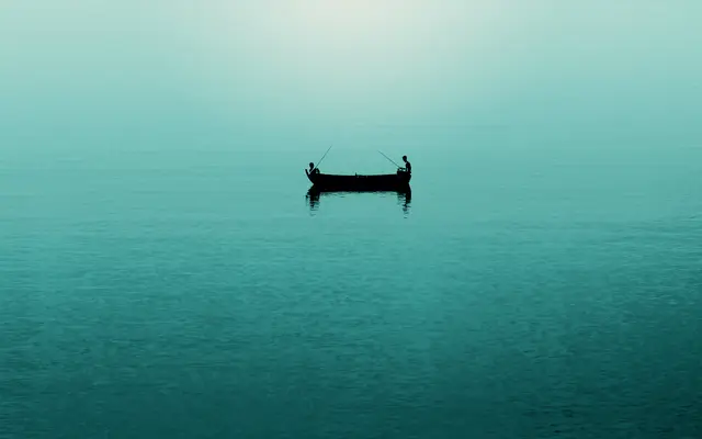 Two anglers in a small boat on calm teal water