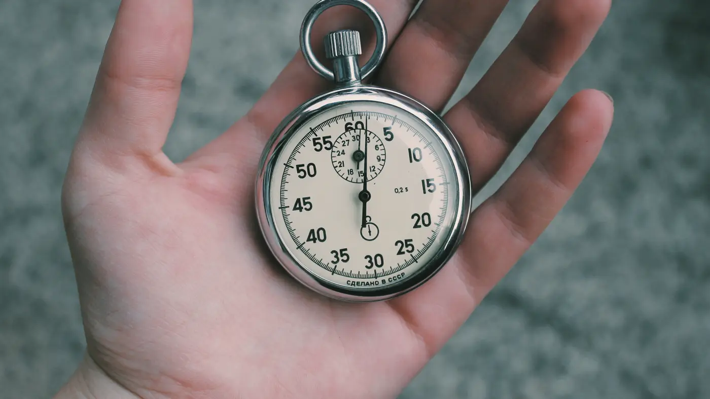 Open hand holding a silver stopwatch