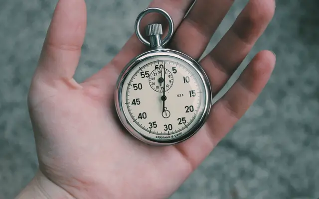 Open hand holding a silver stopwatch