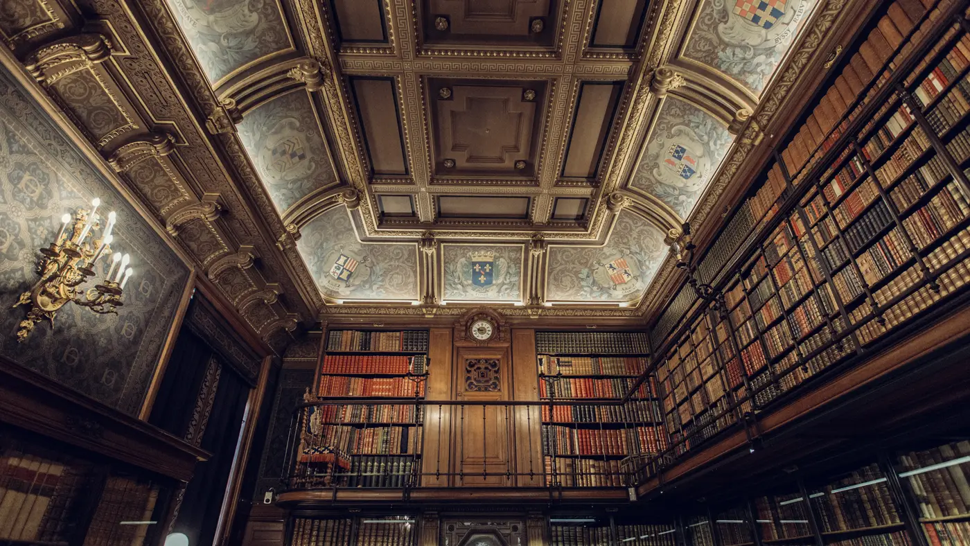 Quiet wood-panelled library with tall shelves of old books