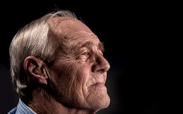 Portrait of a thoughtful older man against a dark background