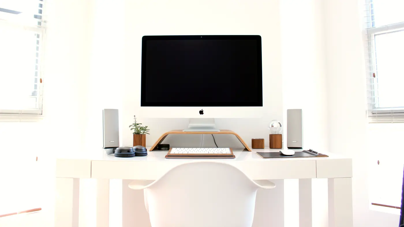 Minimal white home office desk with a desktop computer