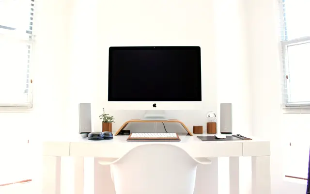 Minimal white home office desk with a desktop computer