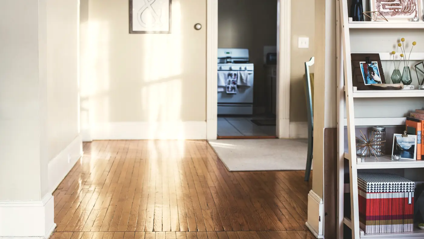 Quiet empty room with wooden floor and an open doorway