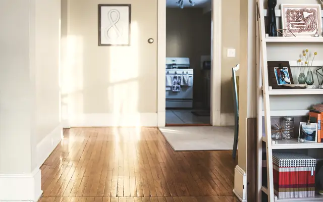 Quiet empty room with wooden floor and an open doorway