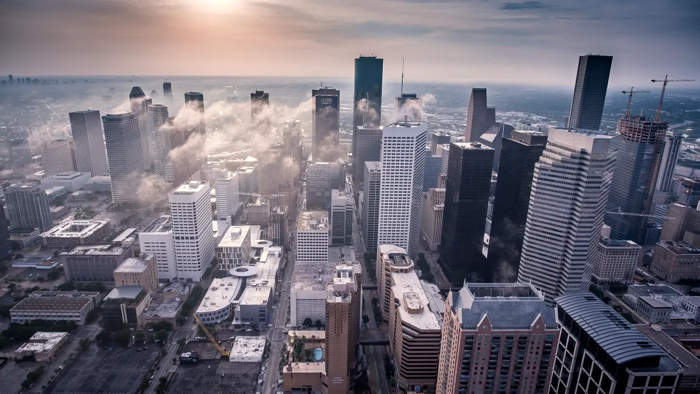 Aerial view of downtown Houston towers with low clouds