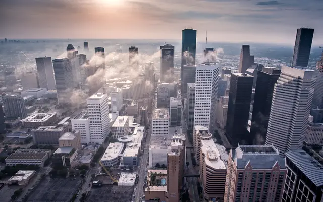 Aerial view of downtown Houston towers with low clouds