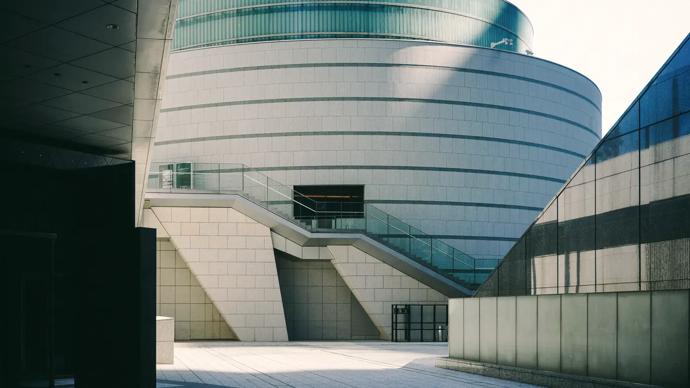 Rounded contemporary building with glass bands and pale stone