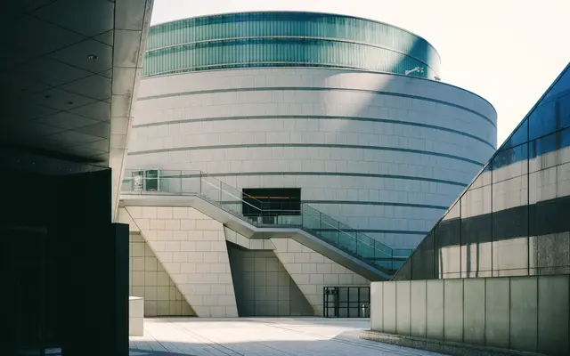 Rounded contemporary building with glass bands and pale stone
