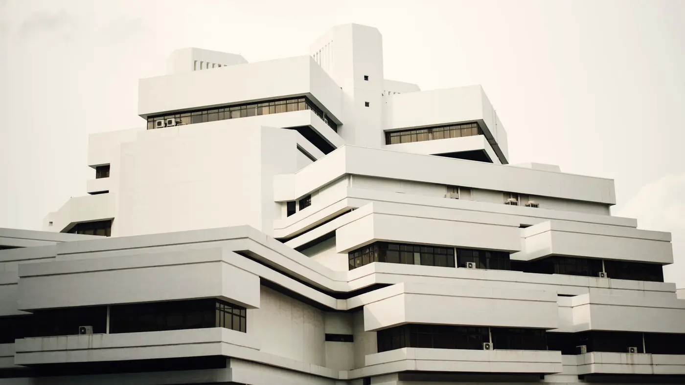 Stepped white modernist building against a pale sky