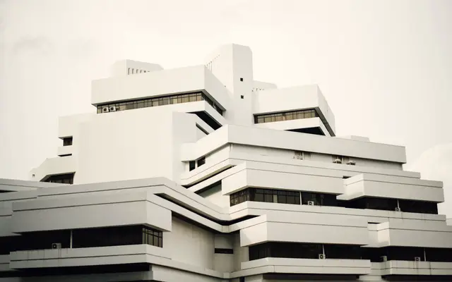 Stepped white modernist building against a pale sky