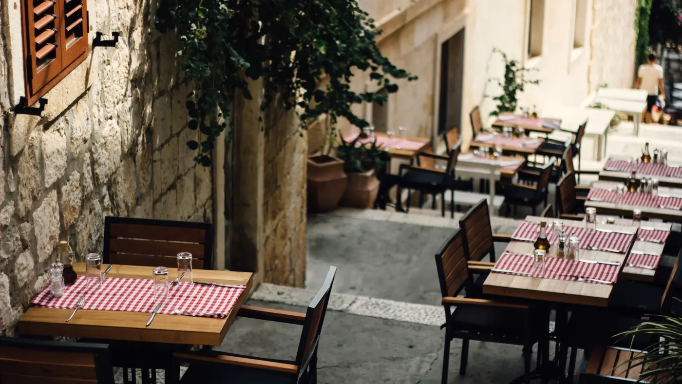 Restaurant terrace tables set along a stone alley