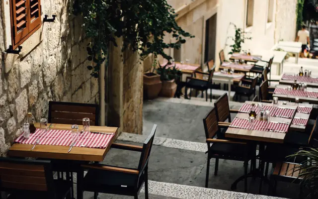 Restaurant terrace tables set along a stone alley