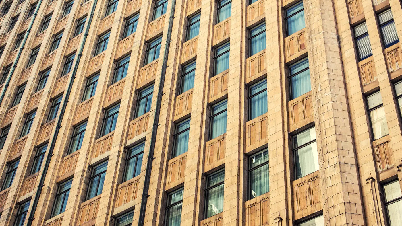 Sandstone office building facade with rows of tall windows